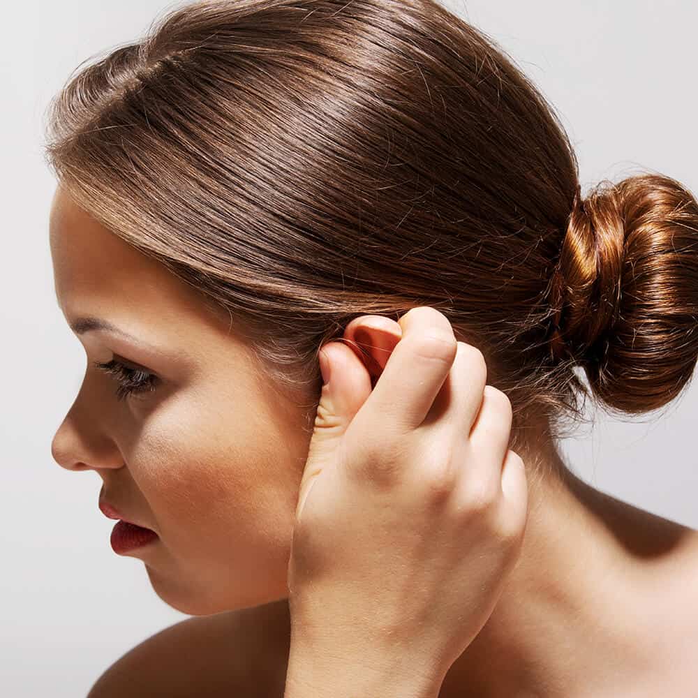 woman holding her ear