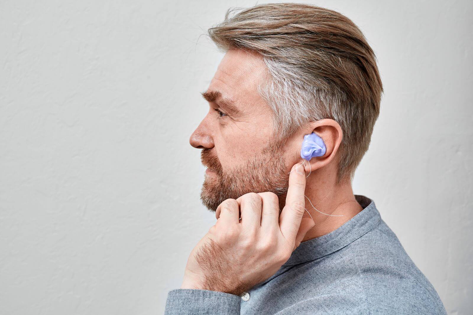 Man with custom hearing aid fitting molding in ear